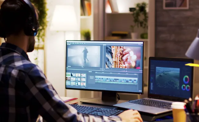 Video editor working on dual monitors with a cinematic timeline and color grading tools, providing professional video editing services including wedding video editing, VFX, and motion graphics for a video editing agency.