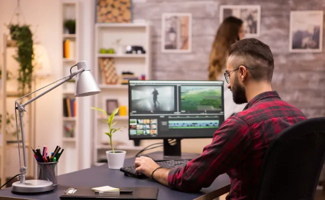 Video editor creating short-form content on dual screens, featuring trendy edits for social media platforms like Instagram Reels, TikTok, and YouTube Shorts, highlighting outsourced video editing services.