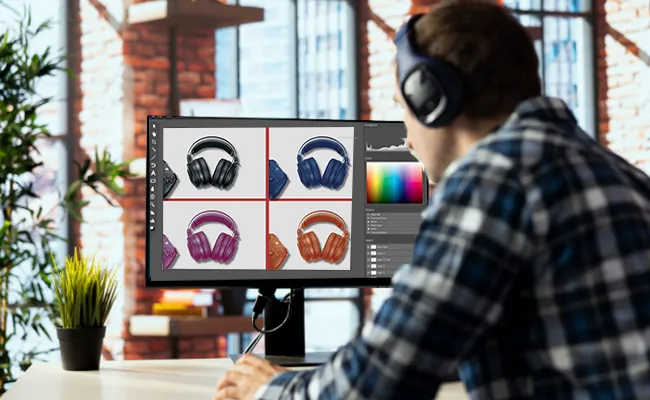 Man editing multiple headphone product images on a desktop monitor with color correction and background adjustments, ideal for businesses outsourcing photography editing for e-commerce platforms like Amazon and Shopify.