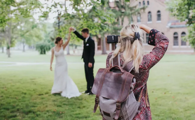 Wedding videographer filming a bride and groom dancing outdoors, illustrating the balance of emotional highlights and full-day coverage when deciding How long should a wedding video be