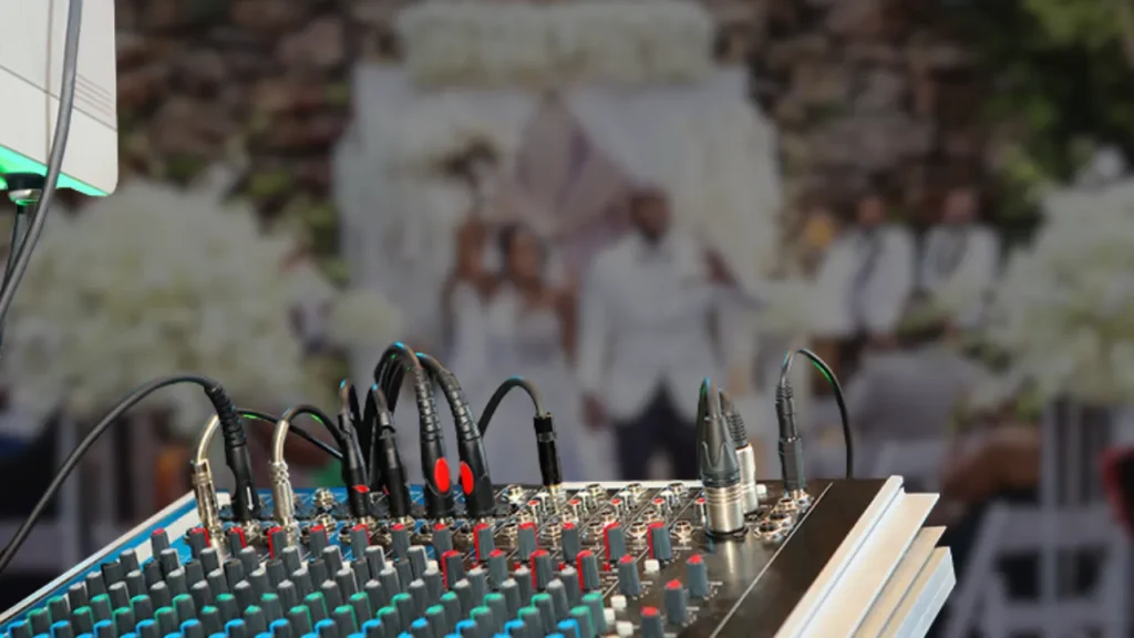 Close-up of audio mixer with cables set up at a wedding venue, emphasizing the importance of sound design and music selection in creating emotionally impactful wedding highlight videos
