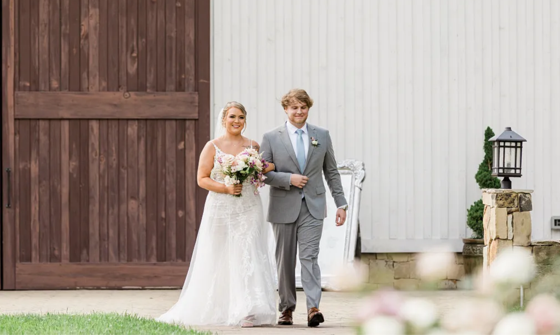 Bride walking with groomsman outside rustic wedding venue, ideal moment for cinematic wedding video editing with smooth transitions and emotion-driven pacing for social media platforms.