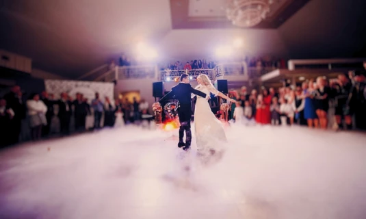 Bride and groom dancing on a fog-filled wedding reception floor, highlighting audio cleanup and speech enhancement in wedding film editing services.