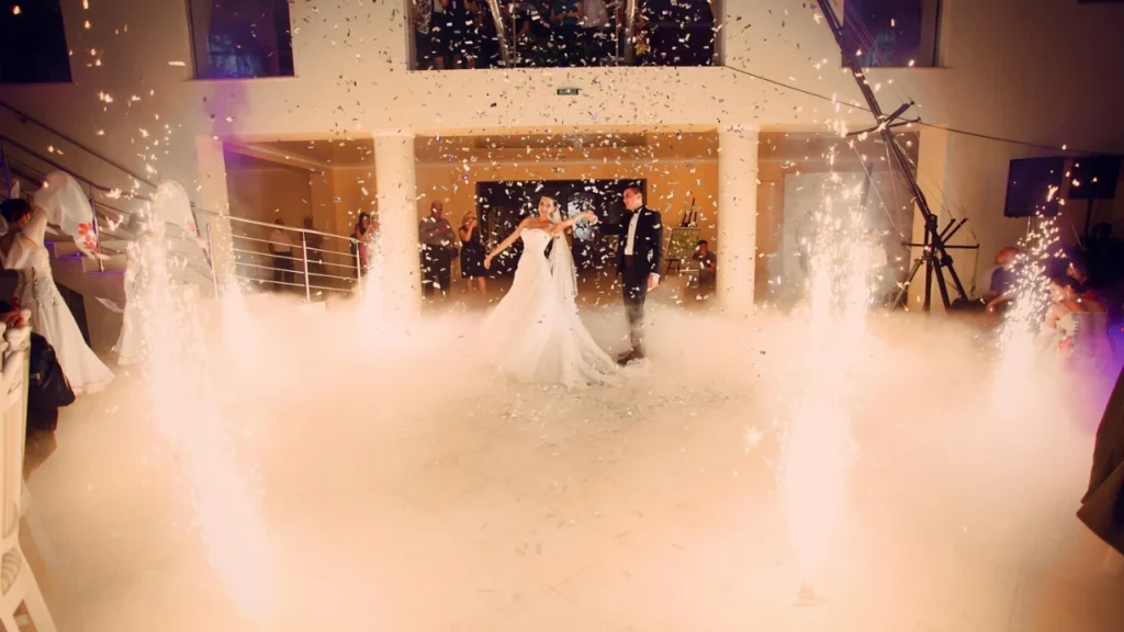 Bride and groom dancing at the wedding reception with confetti, indoor sparklers, and dramatic lighting, showing a creative dance shot for a cinematic wedding video shot list.